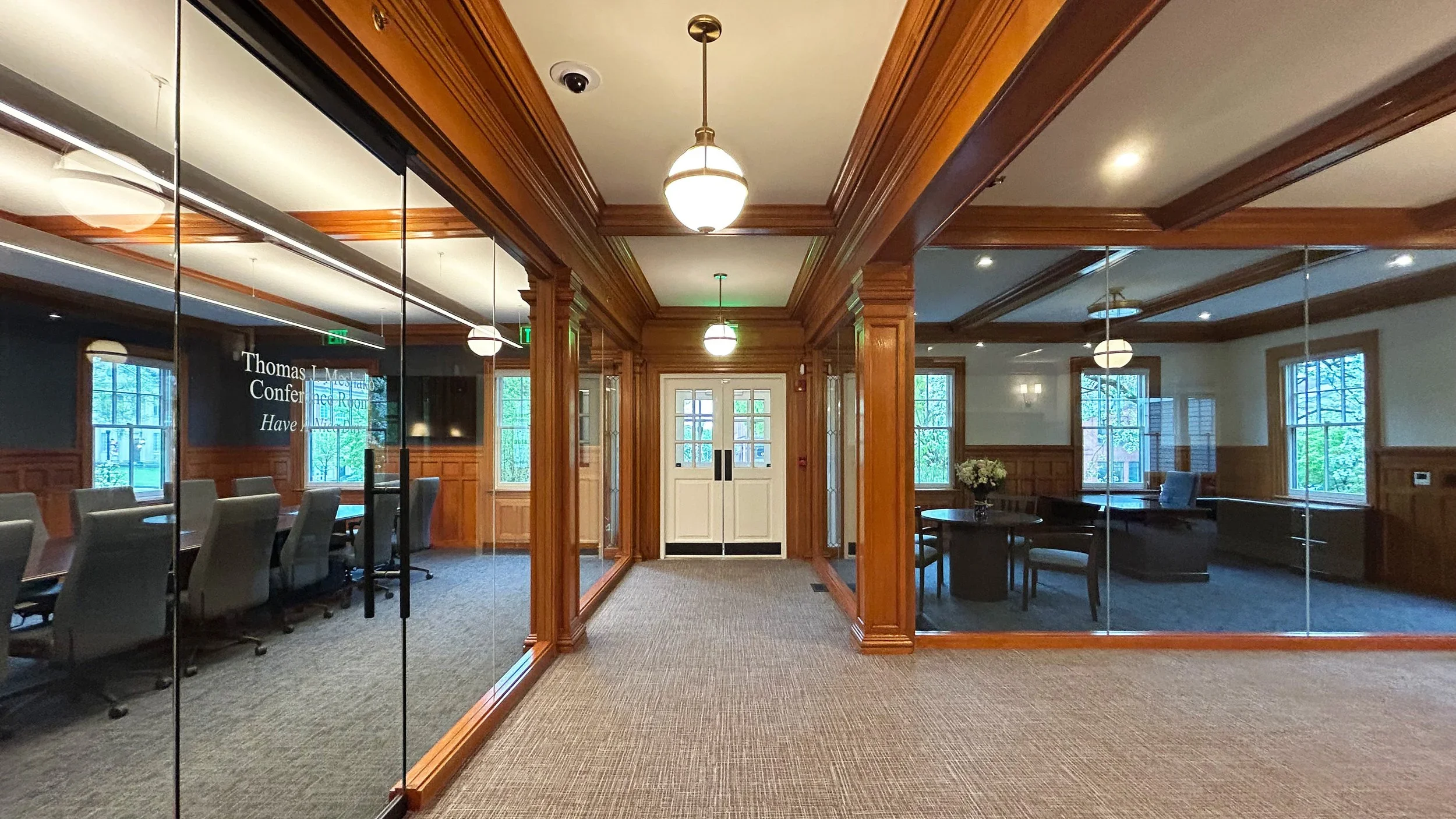 Interior corridor flanked by glass-walled conference and office rooms with rich wooden trim and wainscoting by Bonham & Douglas Architects.