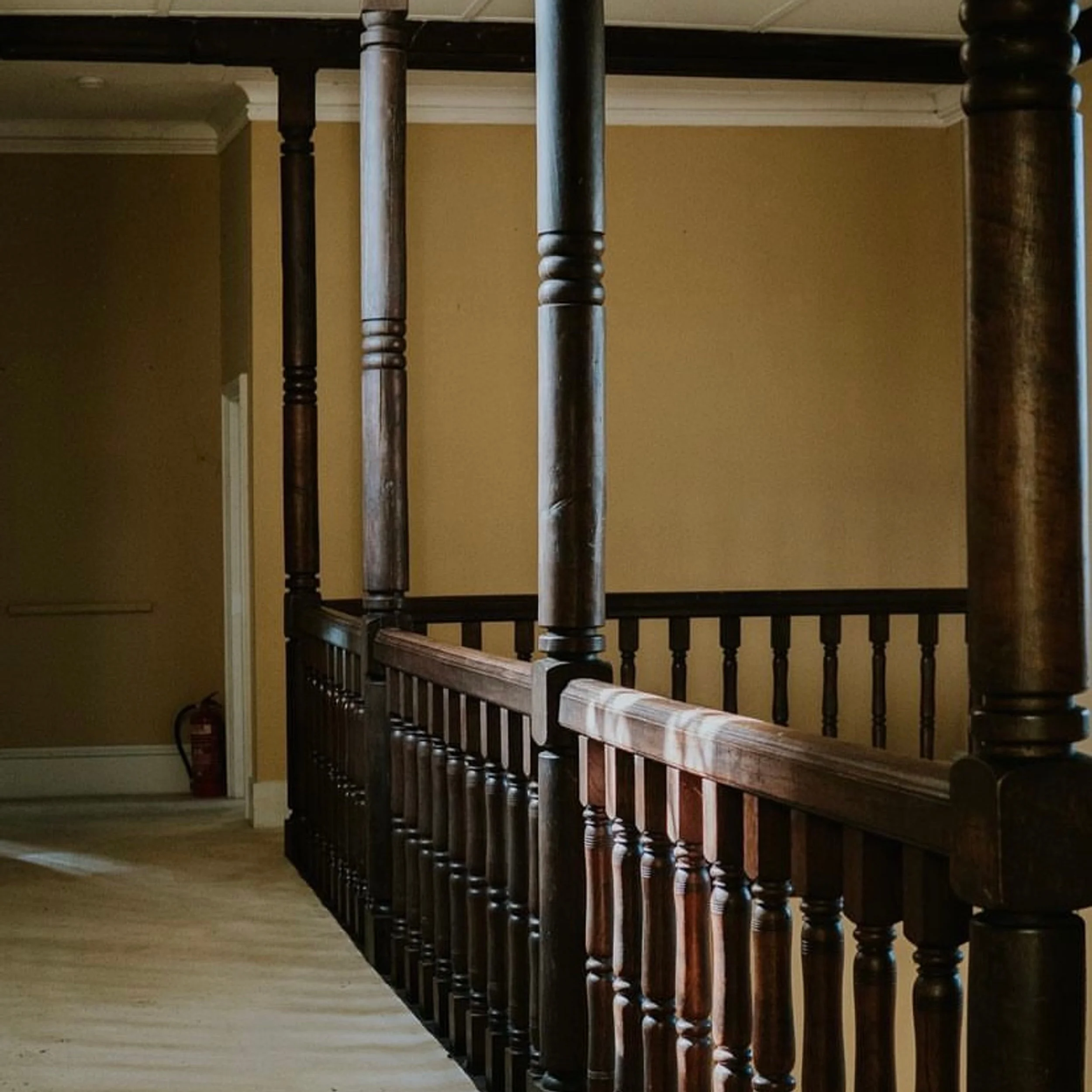 Interior mezzanine balustrade with dark turned timber posts and spindles at Cothelstone Manor by Studio Malaqueen.