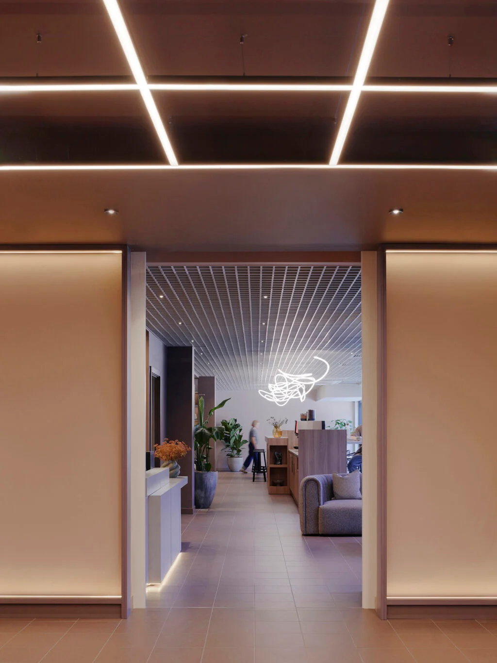 Interior perspective looking through a framed doorway into a lit workspace with grid ceiling and pendant light by The Furniture Practice.