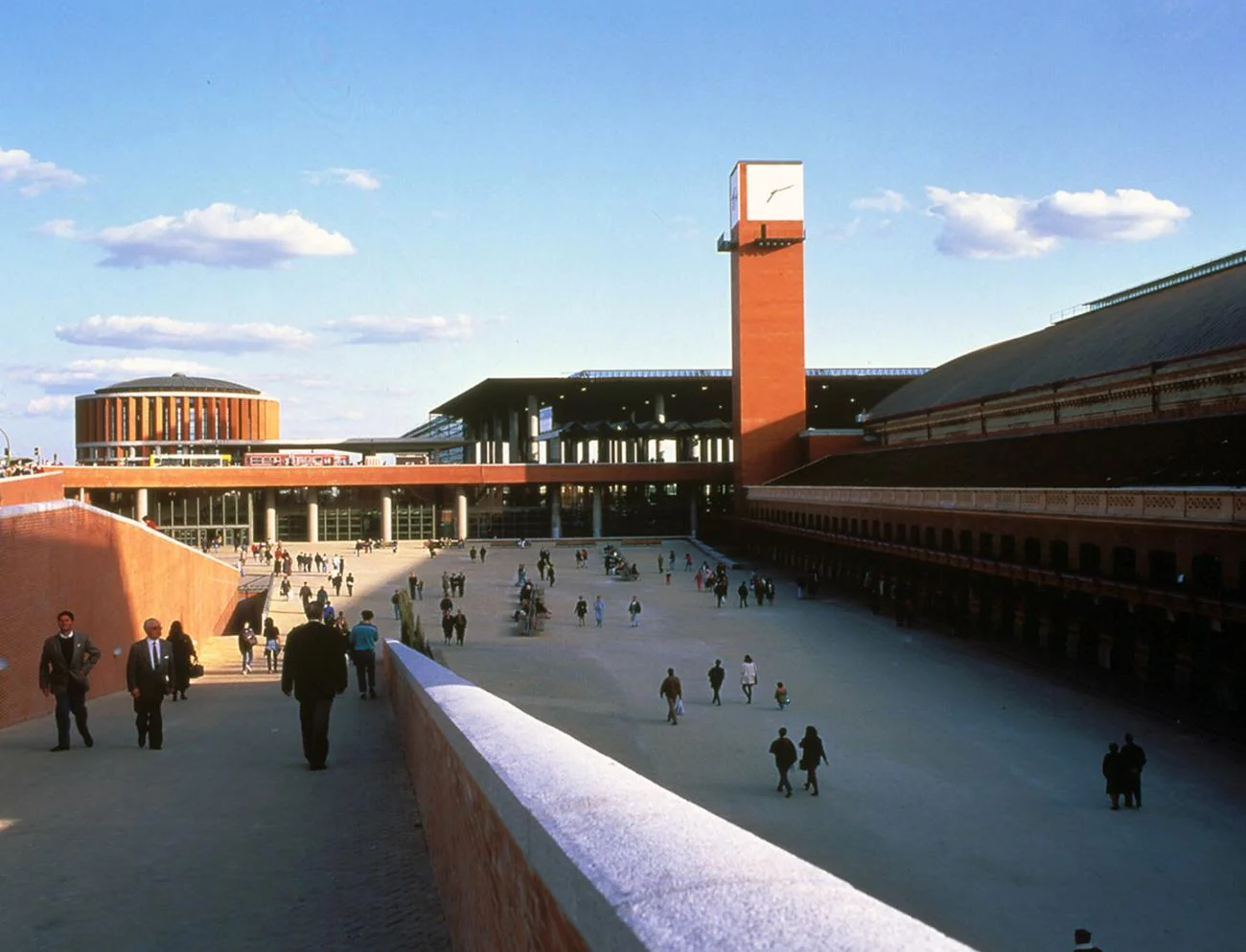 The wide brick pedestrian plaza and clock tower of Atocha Station in Madrid designed by Rafael Moneo.