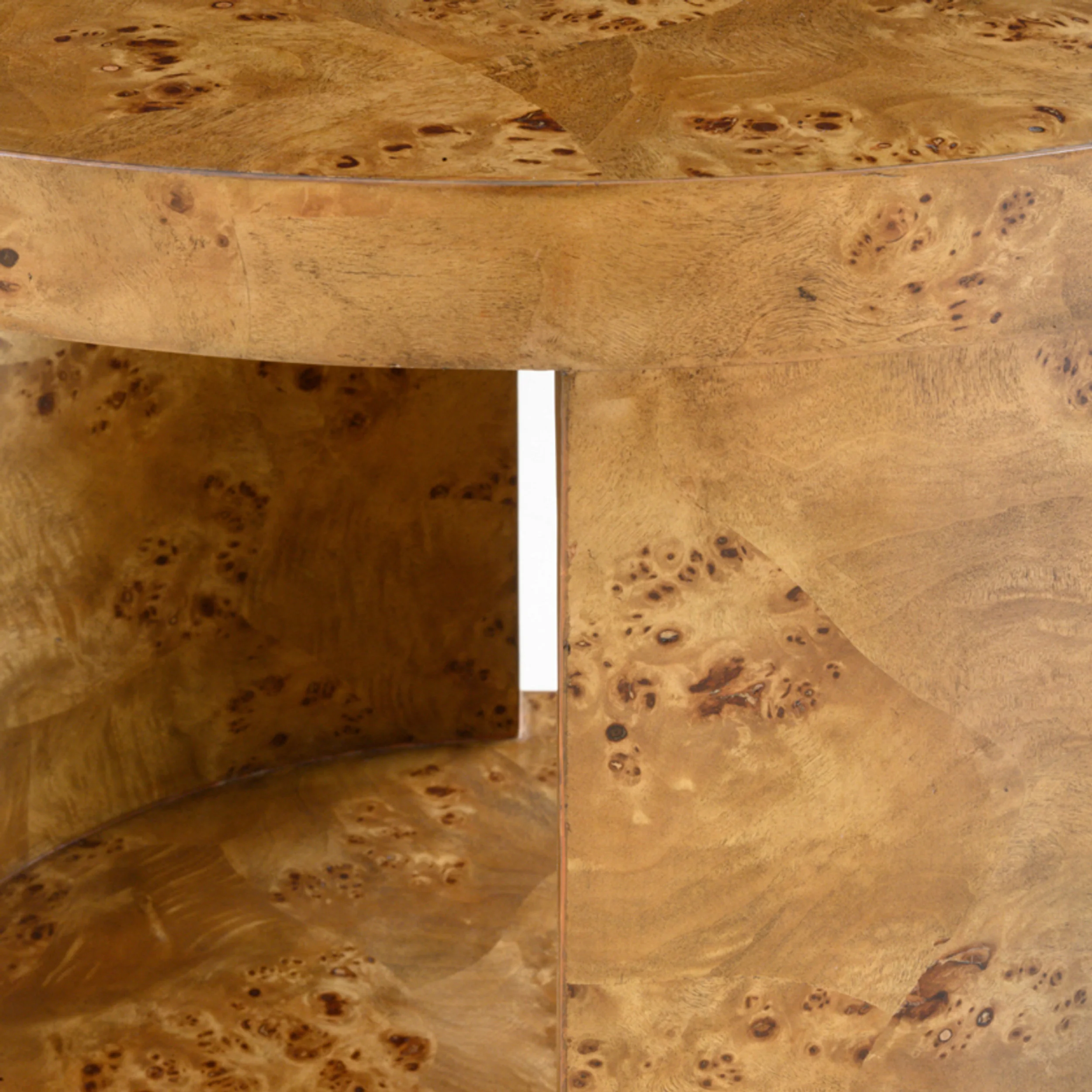 Close-up detail of a round burl wood veneered side table showing highly figured grain and joinery.
