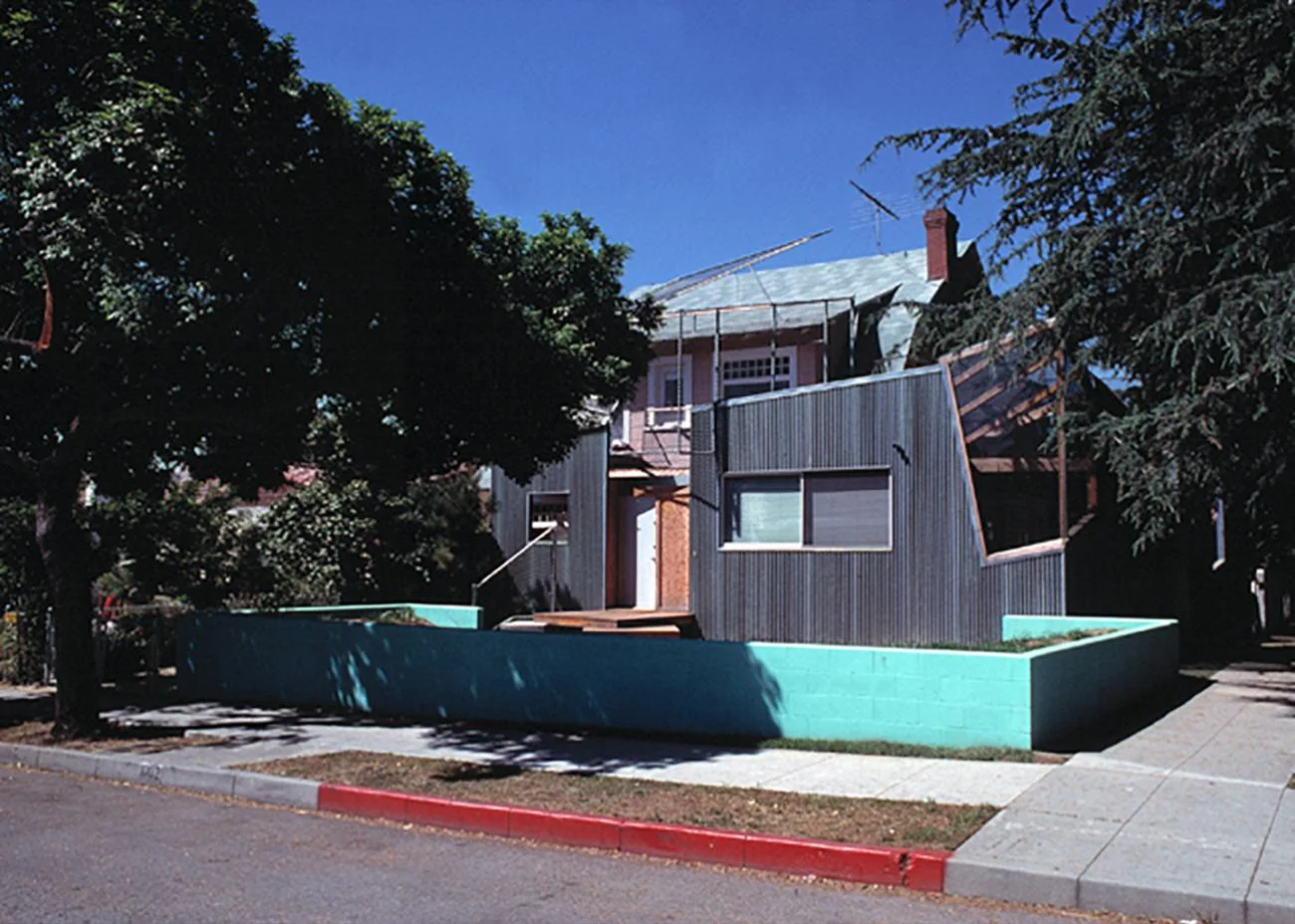 Exterior view of the Gehry Residence in Santa Monica showing the corrugated metal addition wrapping the original house.