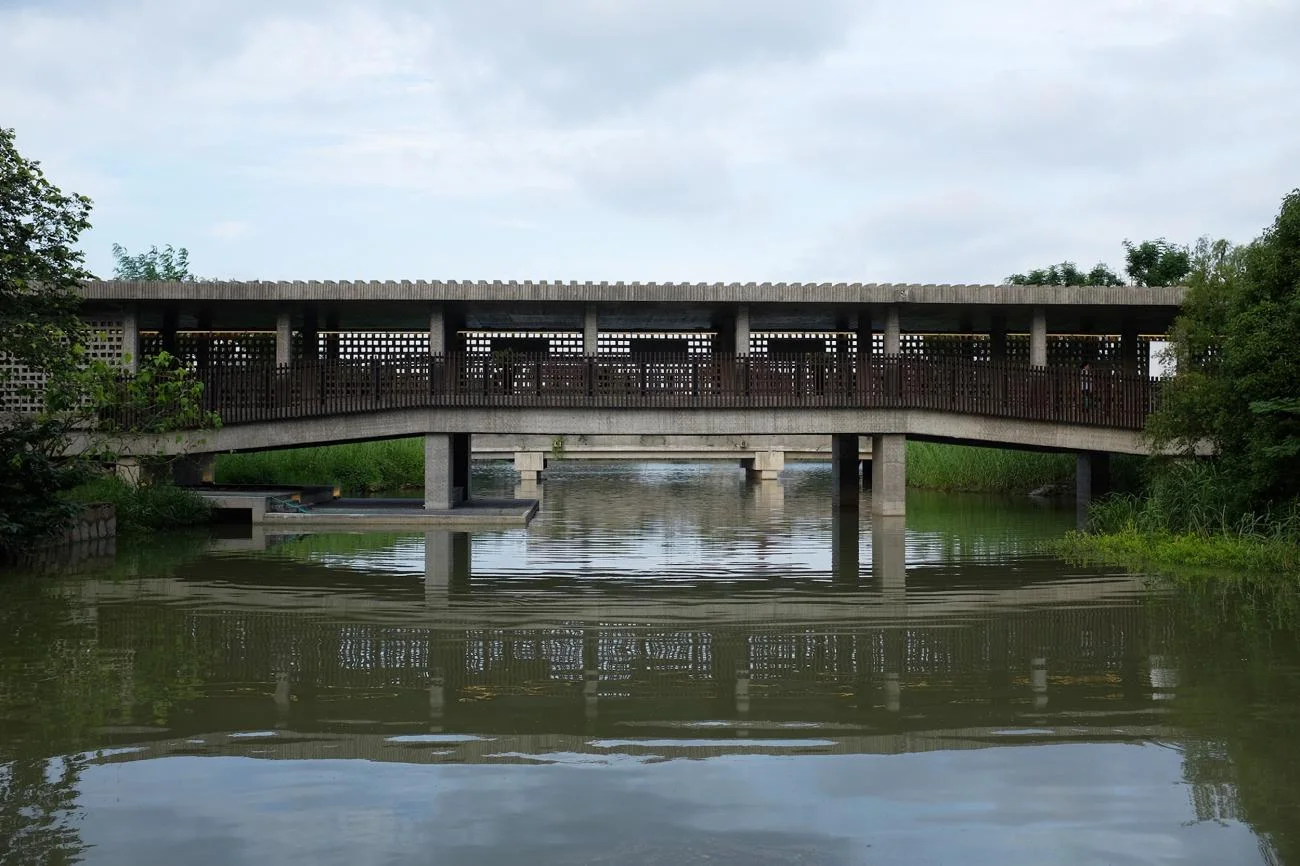 Suzhou Museum of Imperial Kiln Brick by Liu Jiakun, showing a covered concrete bridge reflecting on water.
