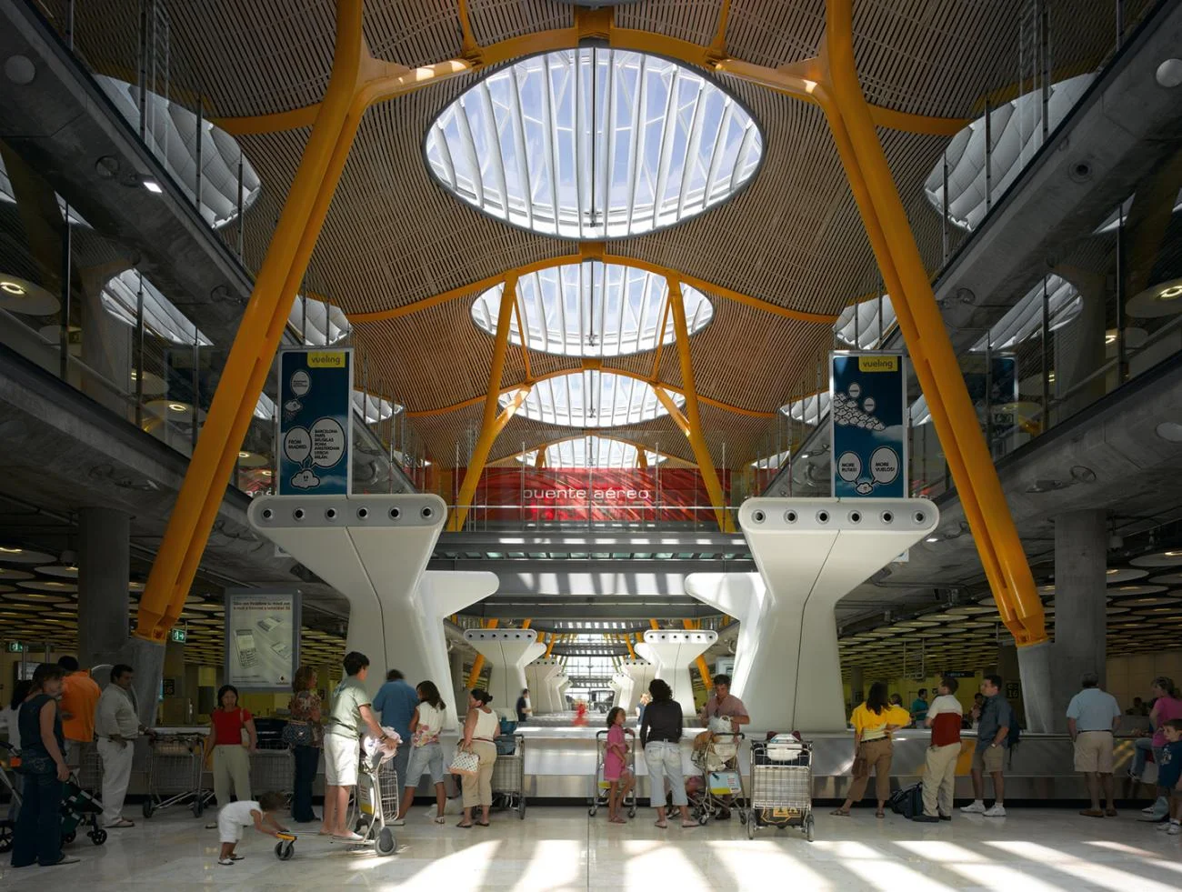 Interior of Madrid Barajas Airport Terminal 4 by Richard Rogers, featuring a bamboo ceiling and yellow columns.