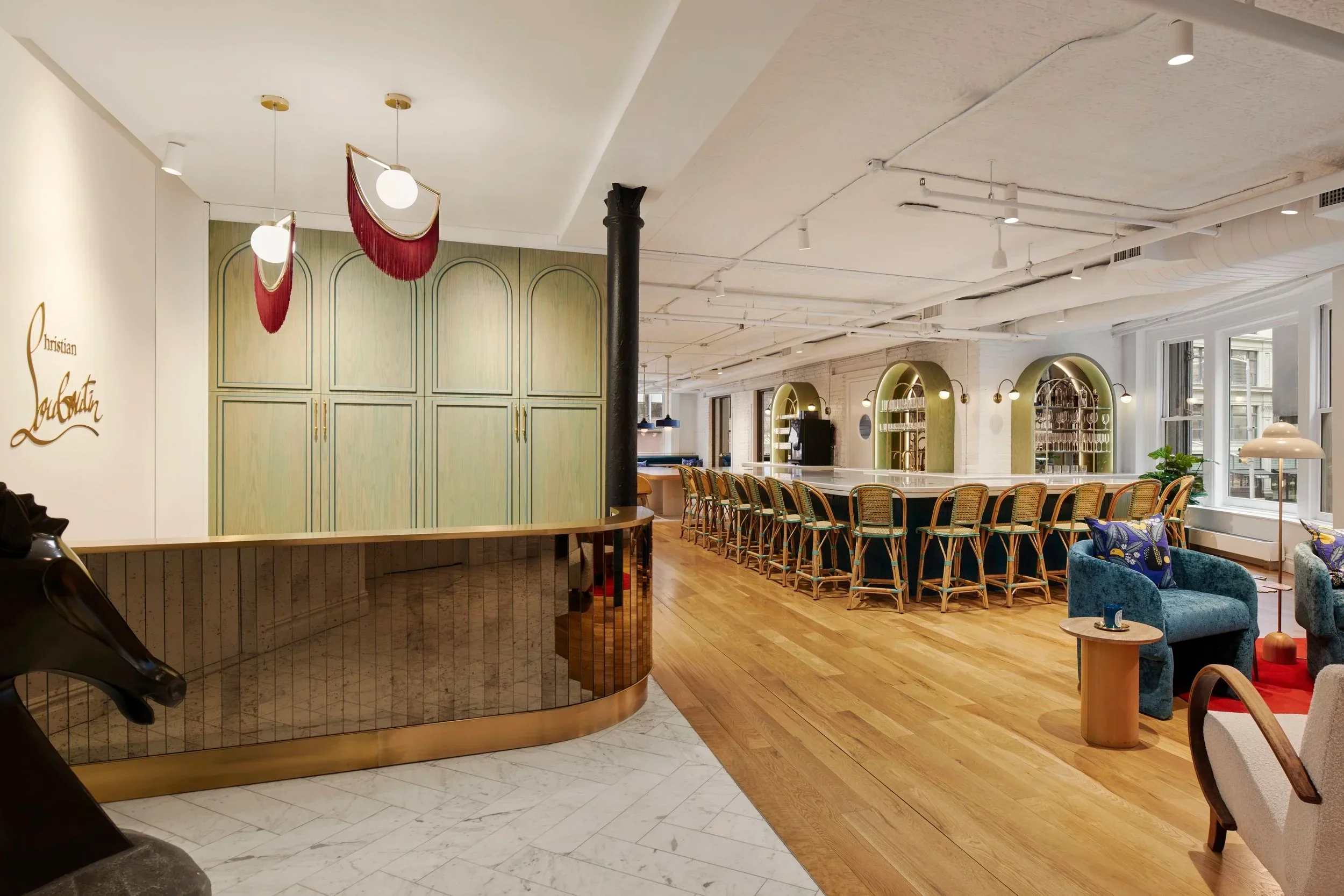 Interior view of Christian Louboutin Americas HQ by Alda Ly Architecture featuring a mirrored reception desk and arched millwork.