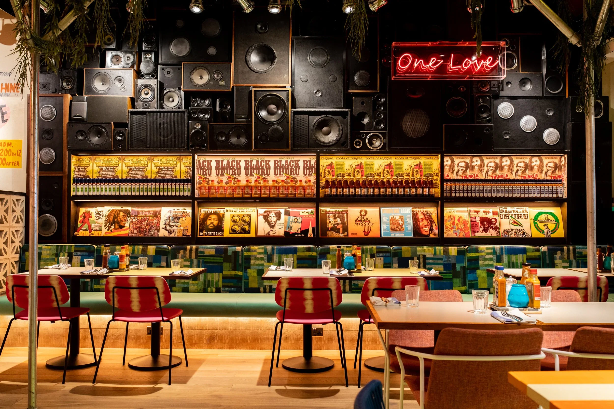Turtle Bay restaurant interior by Fusion Design and Architecture featuring a floor-to-ceiling speaker wall and vibrant booths.