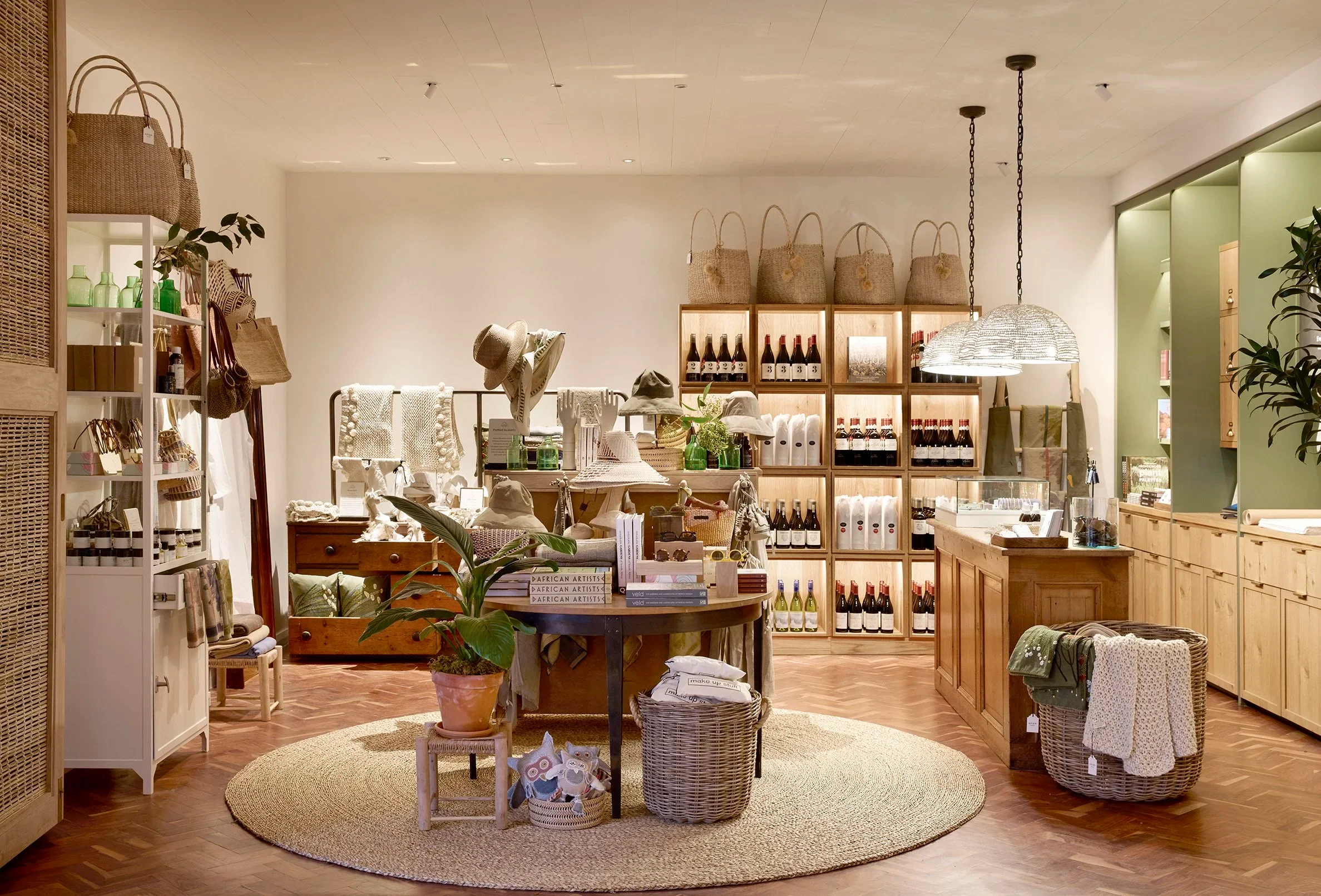 Retail interior featuring warm wood shelving, woven baskets, and a central display table by Fusion Design and Architecture.