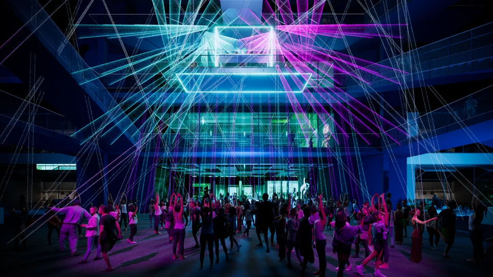 Nighttime atrium with cyan and magenta laser projections illuminating a gathered crowd.