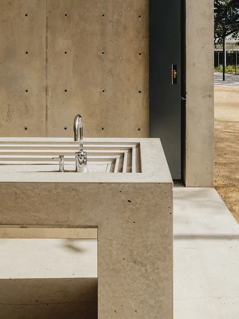 Detail view of a monolithic concrete sink basin and vanity by Michael Hsu Office of Architecture.