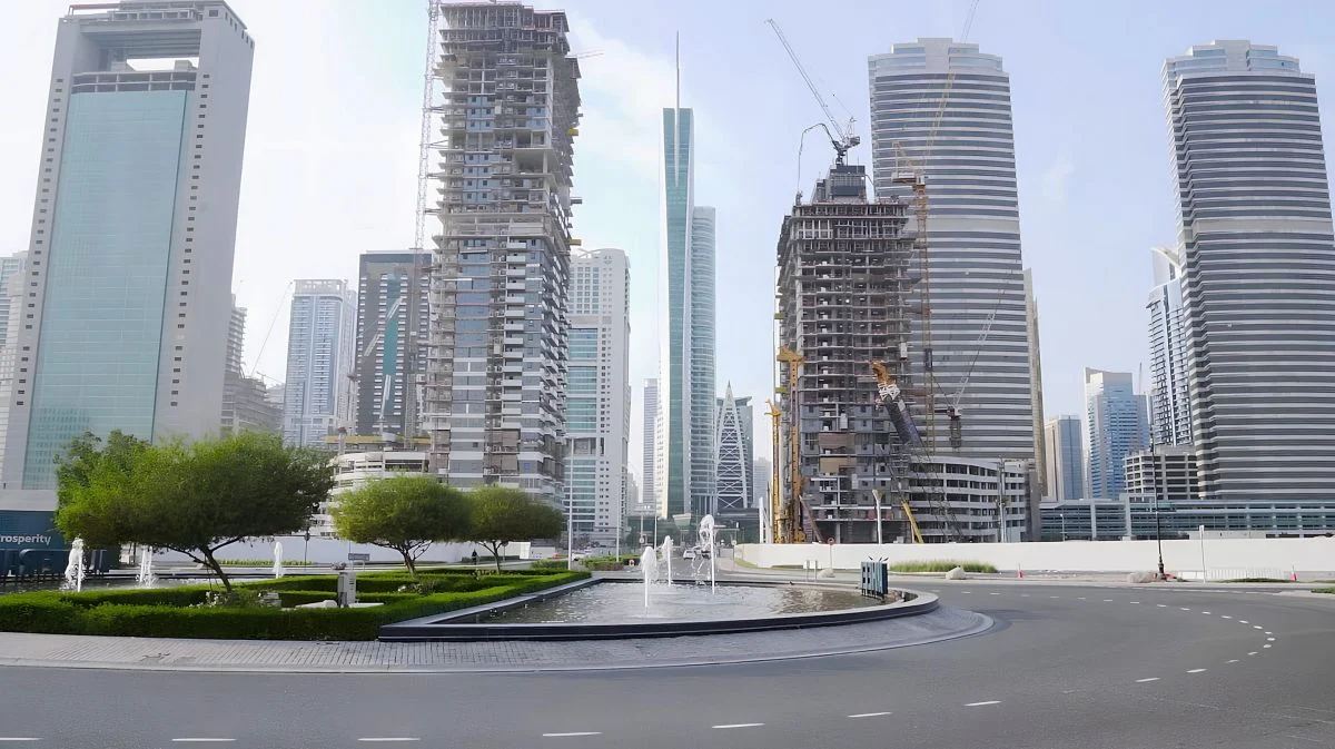 Urban street intersection and water fountain with high-rise towers under construction by Brewer Smith Brewer Group.