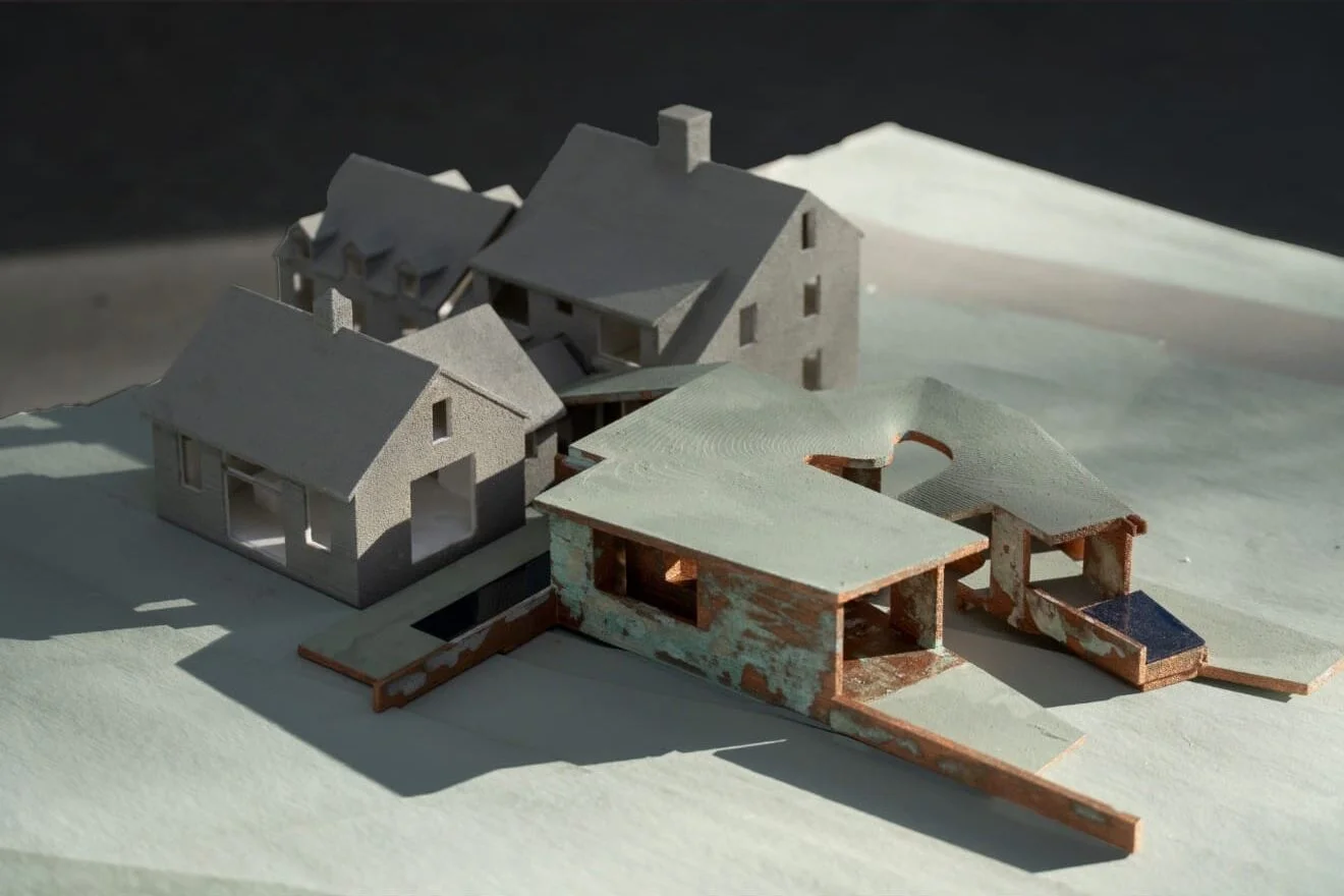 Architectural physical model by Steven Holl Architects showing a complex of gabled volumes and a curved-roof pavilion.