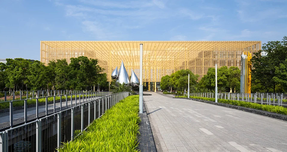 Exterior approach view of Suzhou Bio-Medicine Park featuring a gold-toned screen facade and landscaped pedestrian plaza by WSP.
