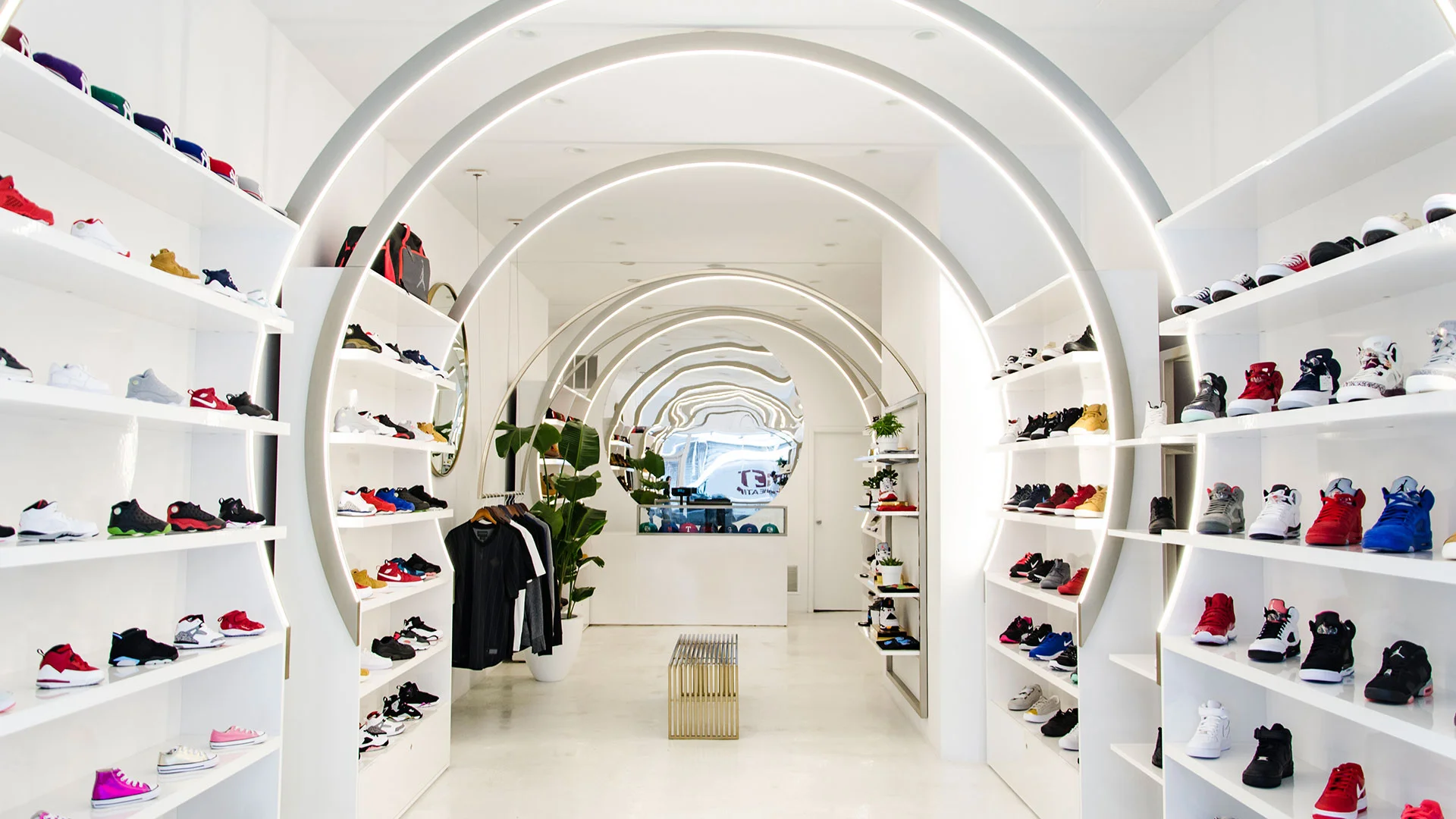 Retail interior with glowing concentric circular archways framing merchandise shelving by Christian Lahoude Studio.