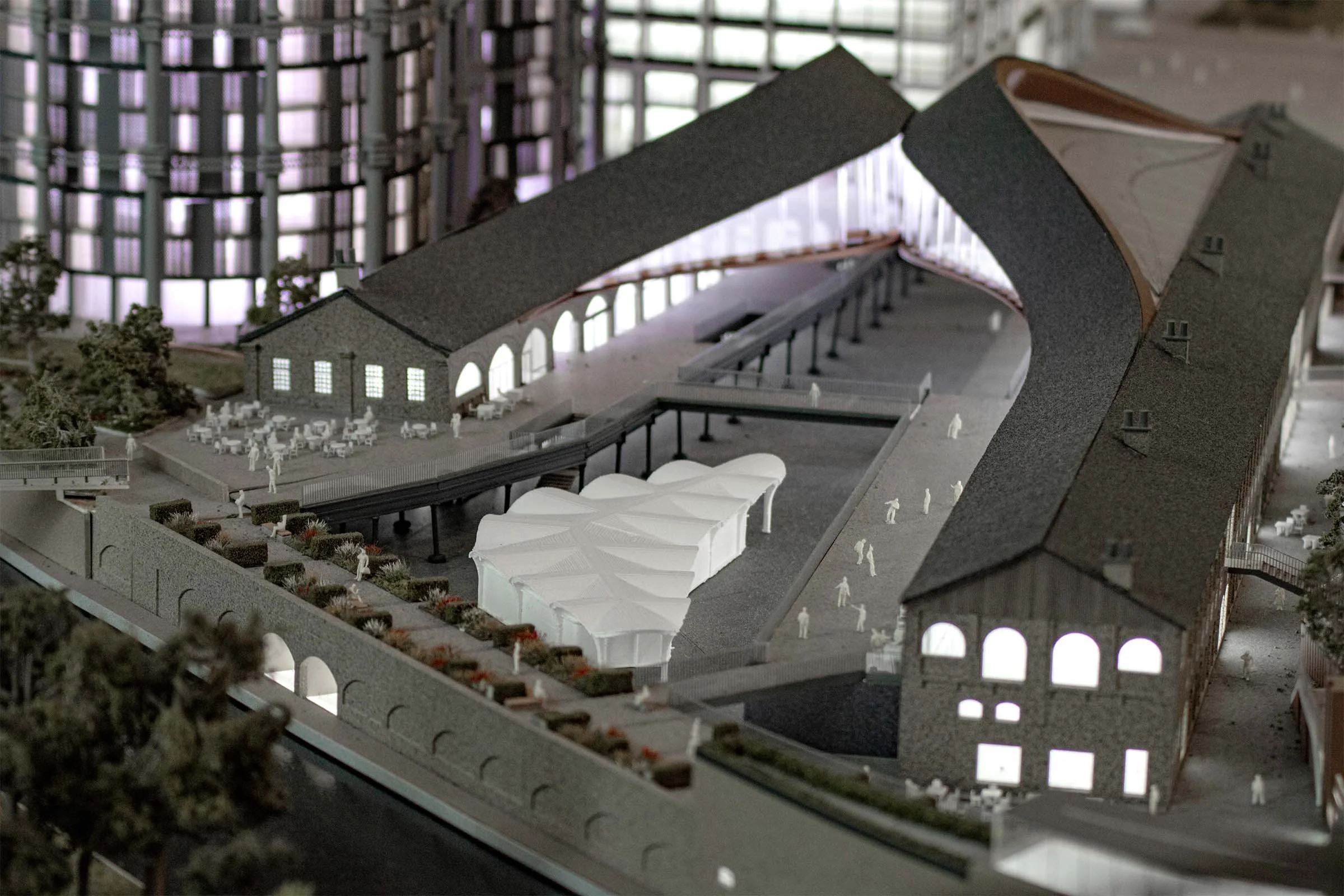 Architectural model of Coal Drops Yard Placemaking by Fathom Architects showing historic gabled brick structures joined by a sweeping curved roof form.