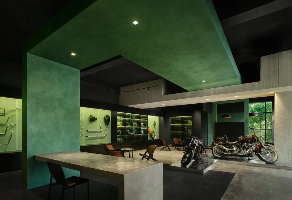 Interior retail space for motorcycles with bold green plaster architectural framing and display walls by Airwall Architecture Office.