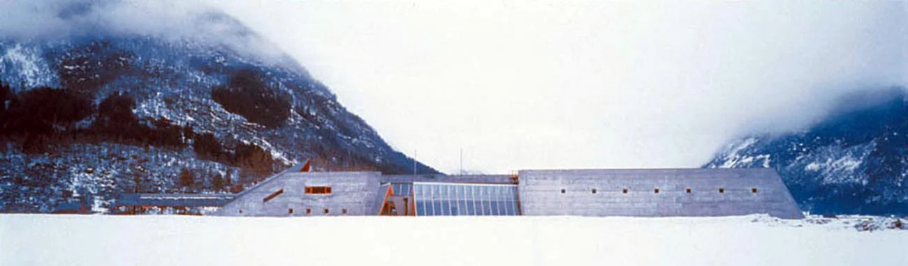 The Glacier Museum in Norway by Sverre Fehn, featuring a long concrete facade set against snowy mountains.