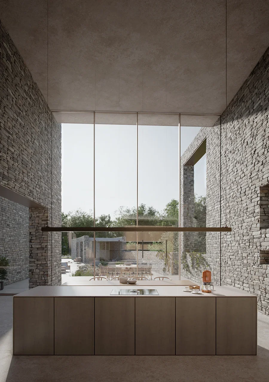 Interior double-height kitchen space featuring dry-stacked stone walls, large floor-to-ceiling glass, and a minimal island by PAD studio.