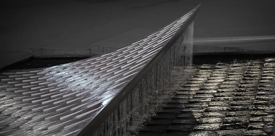 Close-up of a sharp-edged sculptural water feature with rippling flow over cylindrical studs and stone paving by Mind Studio.