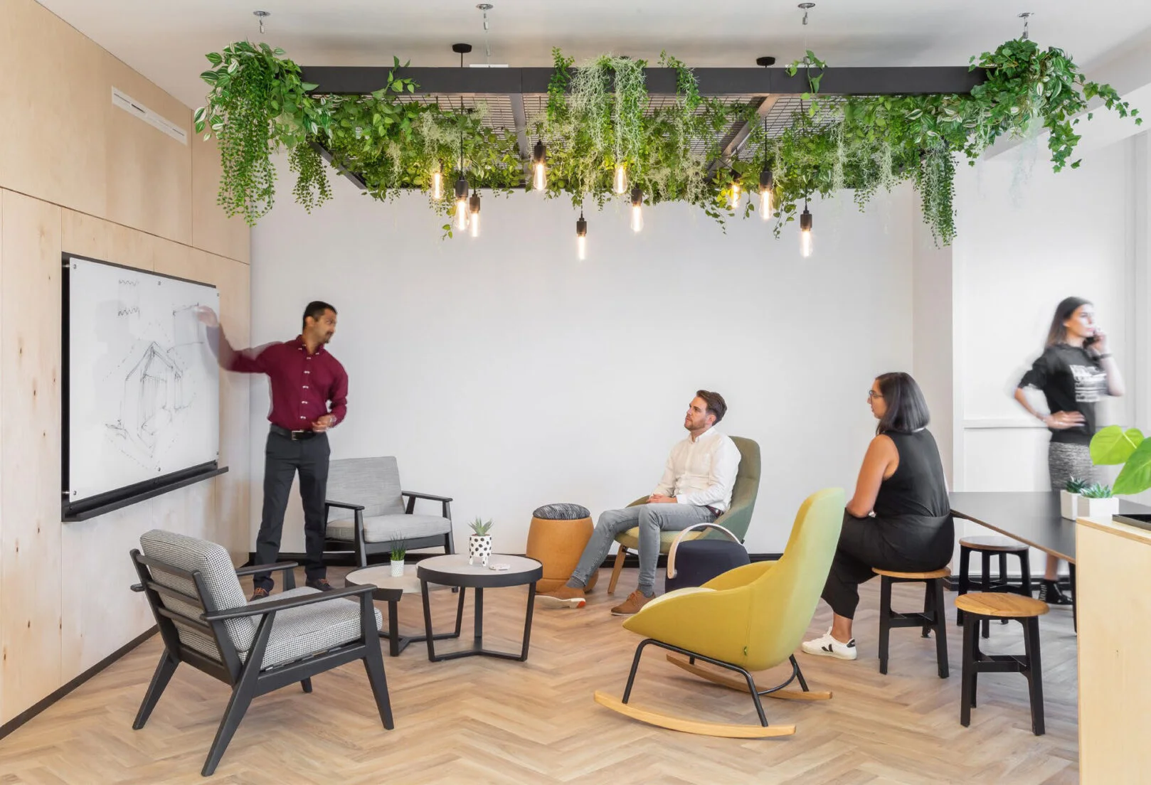 Pick Everard office breakout space with suspended plant canopy, whiteboards, and casual seating.