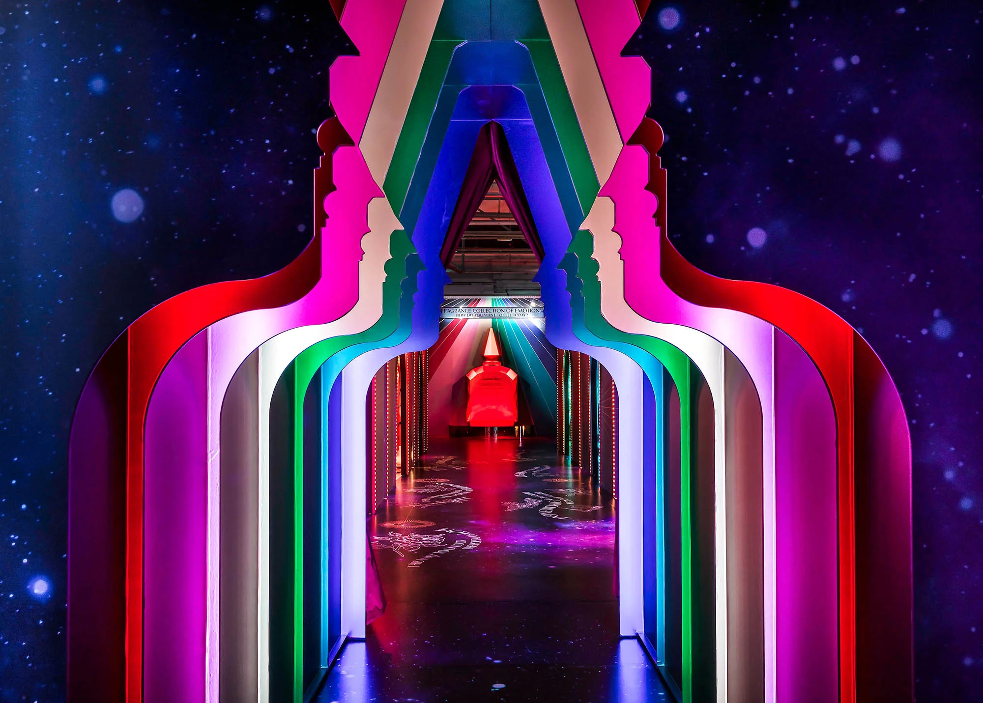 Colorful backlit silhouette arches create a perspective tunnel by StudioXAG.