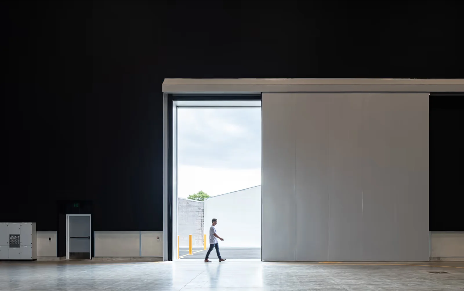 Interior shot of Auckland Film Studios by Ignite Architects, showing a massive sliding industrial door opening to daylight.