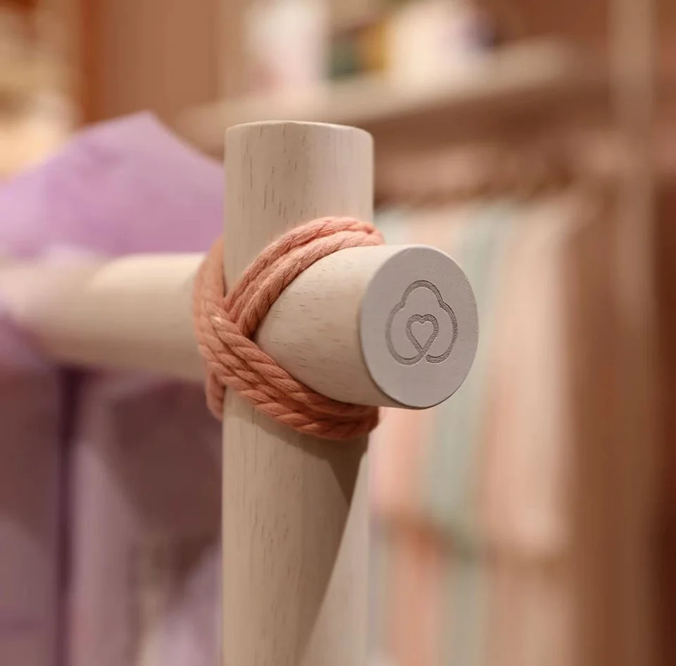 Detail shot of a wooden dowel joint lashed with pink rope by Yees Design.