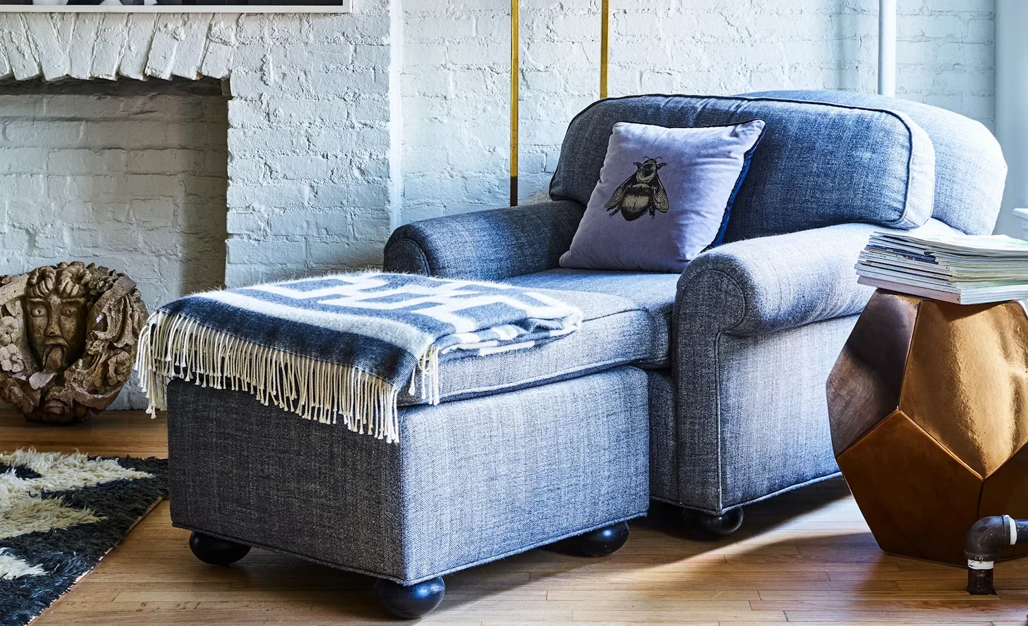 An upholstered armchair with an ottoman in a Williamsburg Townhouse interior by Agencie.