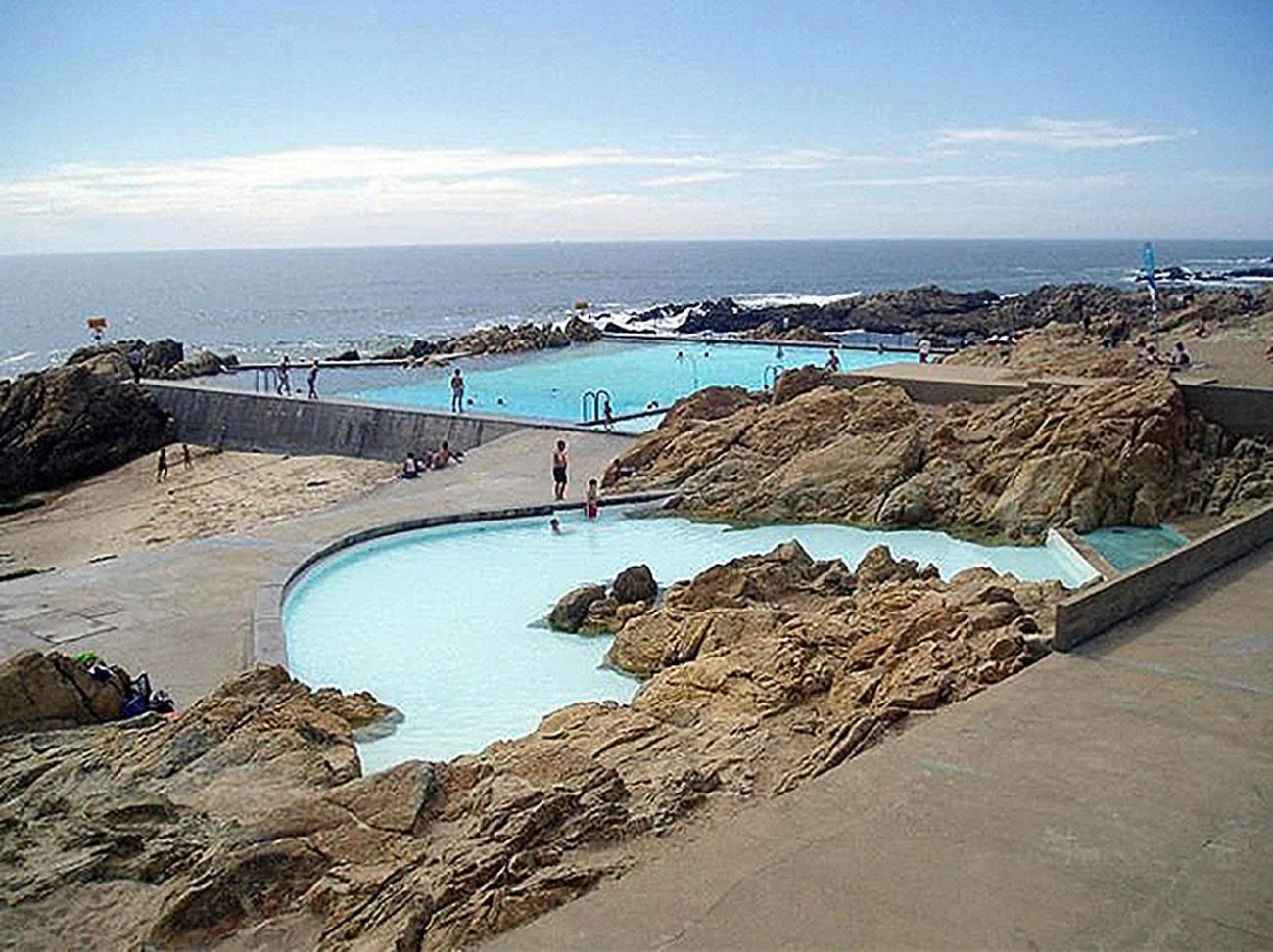 The Leça Swimming Pools by Alvaro Siza, showing concrete basins integrated into rocky coastal shores.