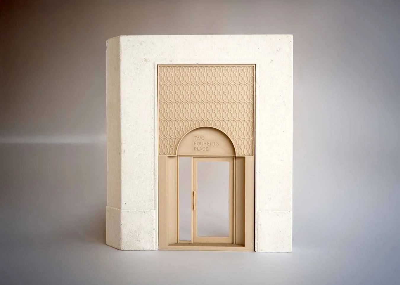 Architectural model of a stone portal with an intricate patterned timber archway and glass door by Dowen Farmer Architects.