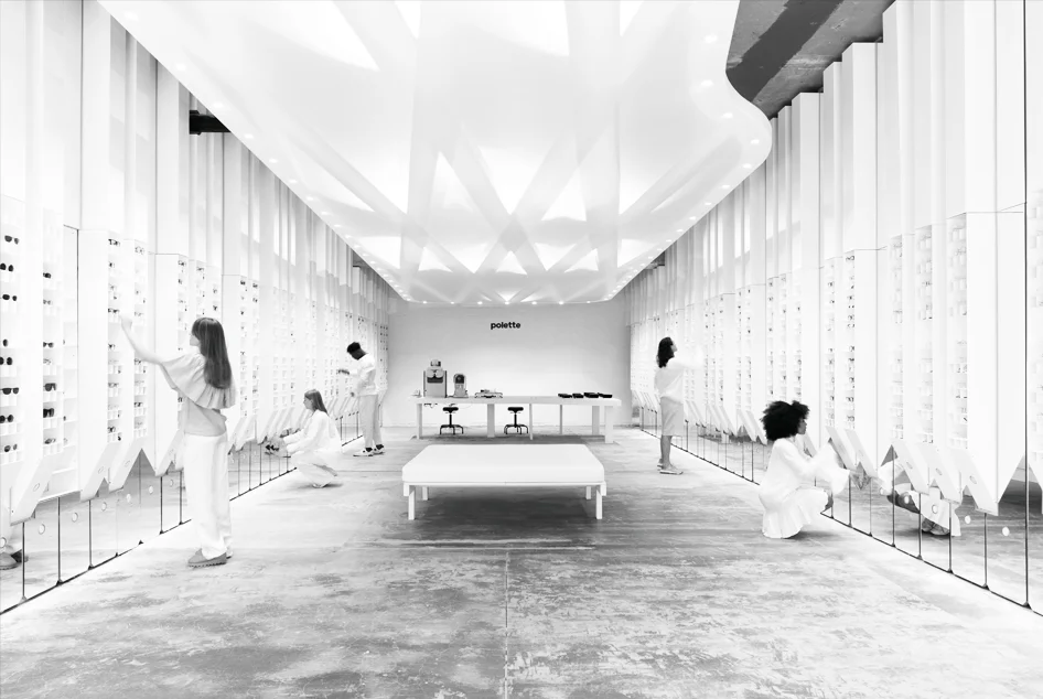 Interior of imagine polette by zU-Studio showing a long symmetrical retail space with backlit faceted ceiling and vertical display fins.