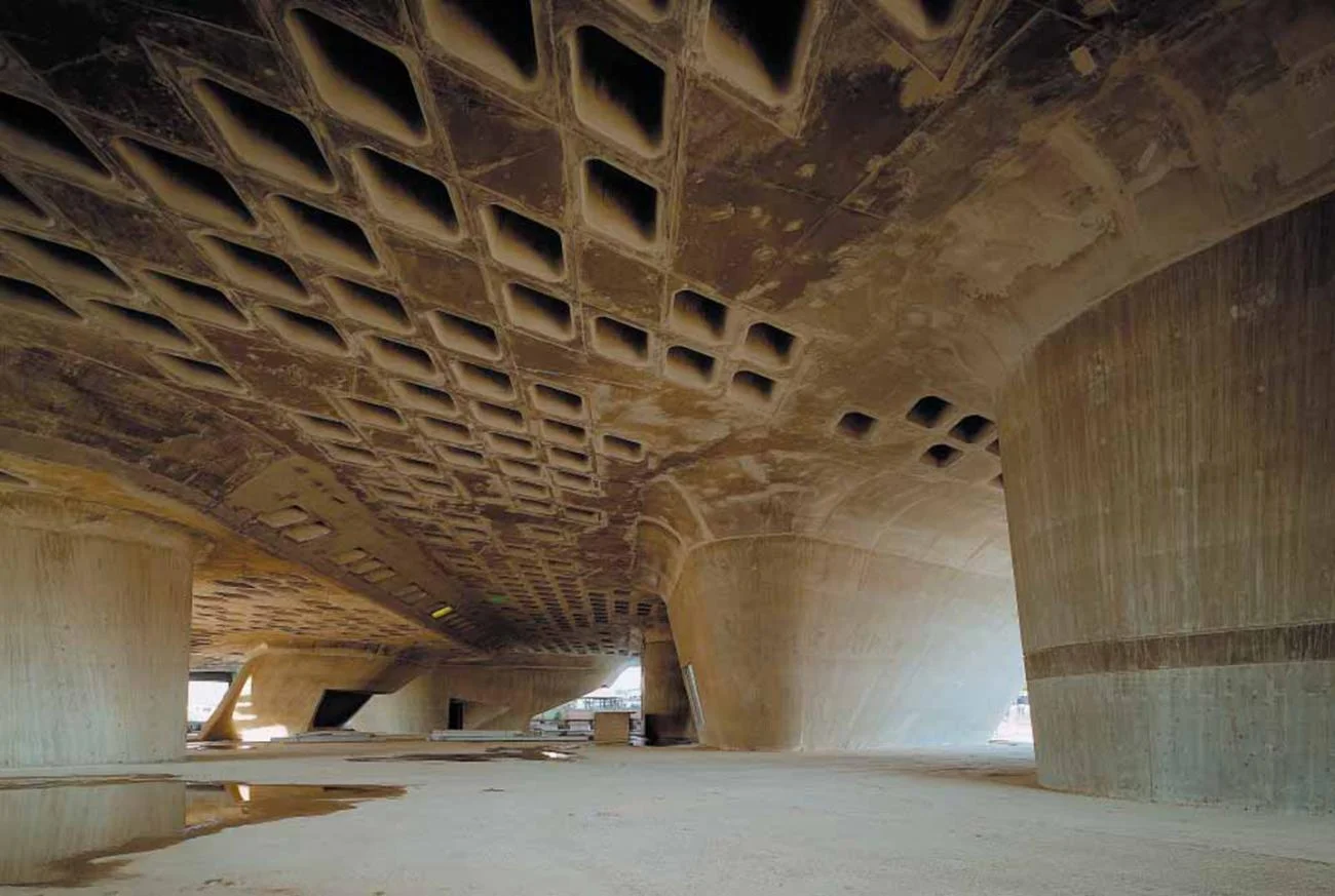 The concrete undercroft of the Phaeno Science Center by Zaha Hadid, featuring conical columns and a coffered ceiling.