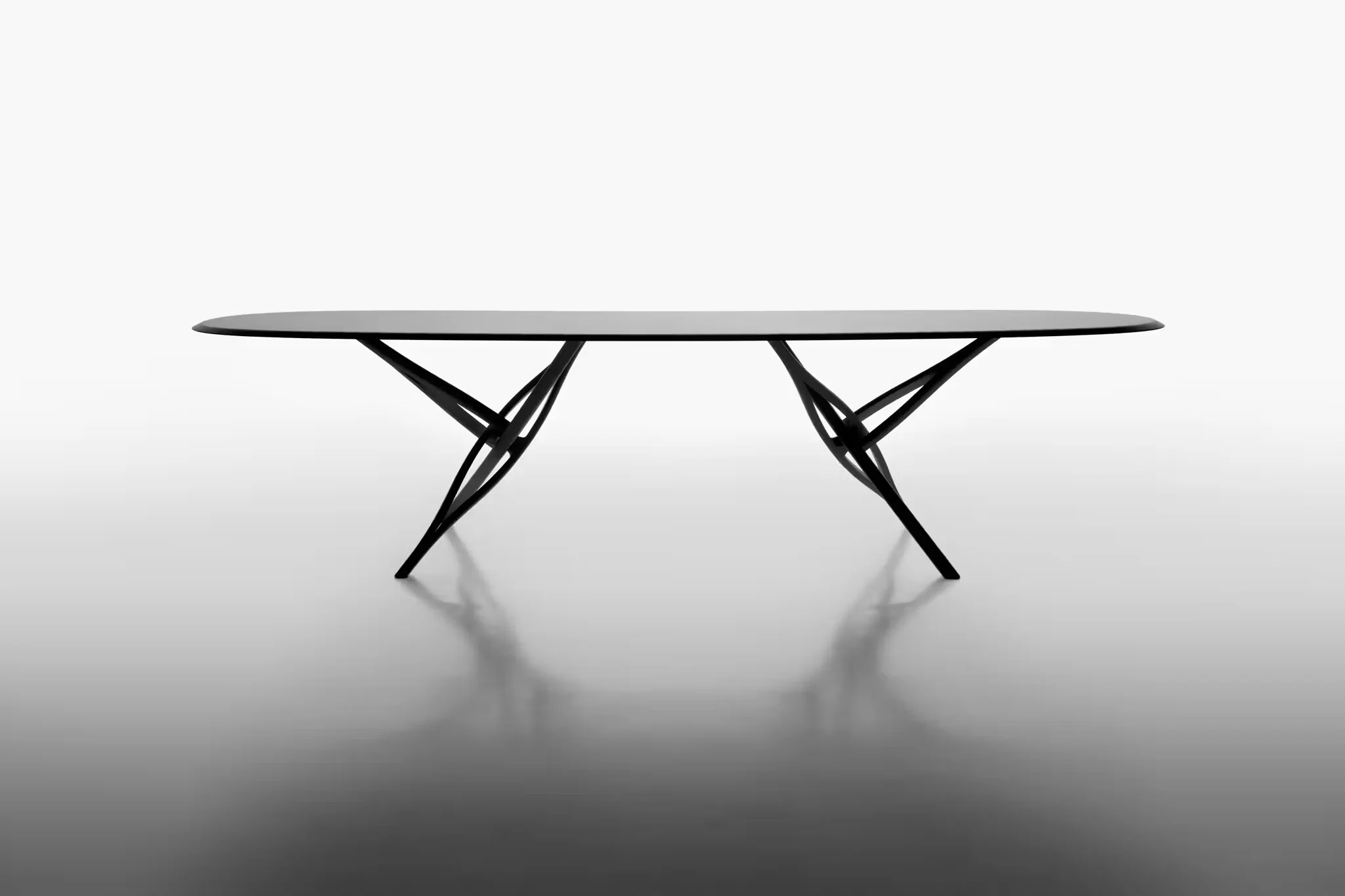 Studio Klass Bowl7xcx black dining table with slender organic intersecting legs against a white gradient studio background.