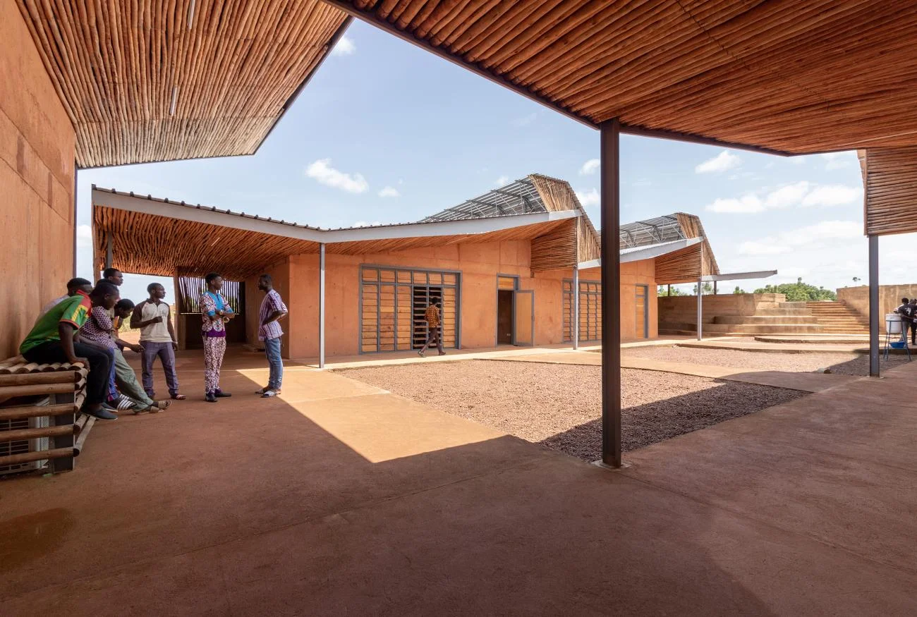 Courtyard of the Burkina Institute of Technology by Francis Kéré, featuring eucalyptus-lined roofs and clay walls.