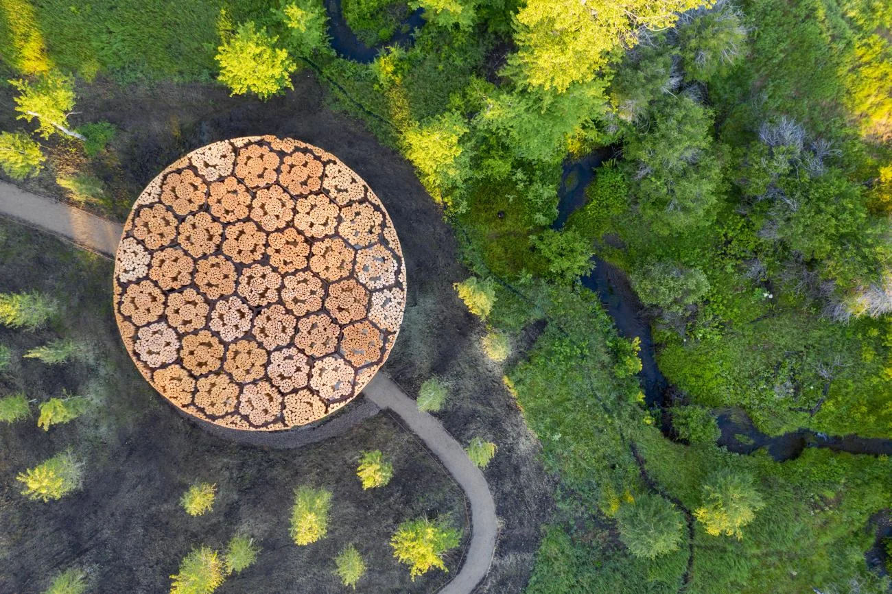 Aerial view of Xylem, a circular timber log pavilion in Montana by Diébédo Francis Kéré.