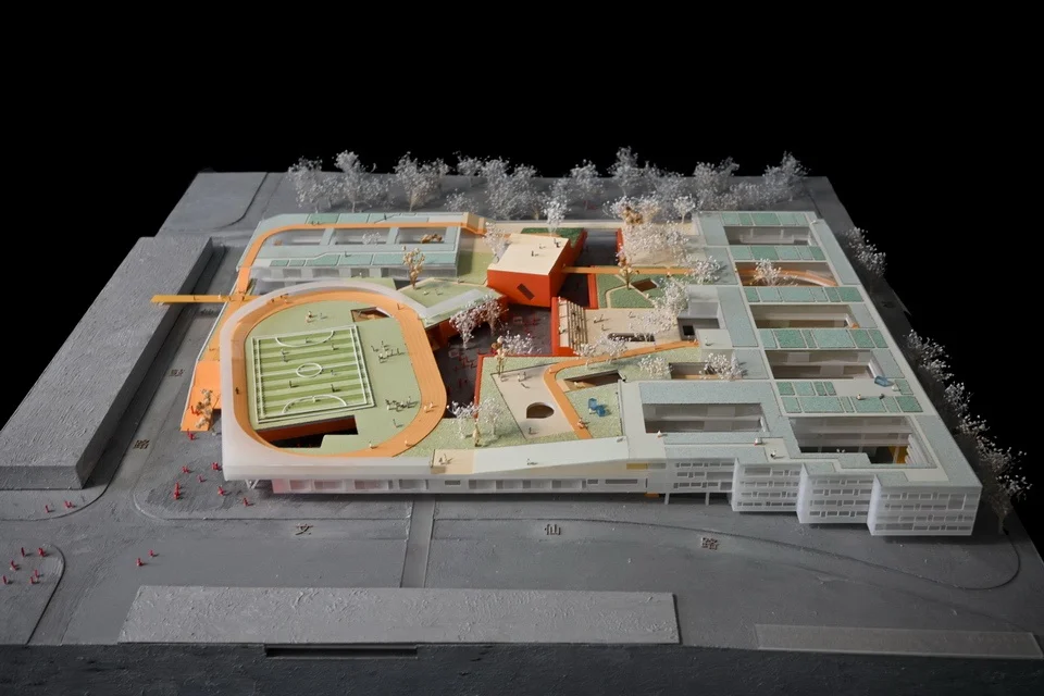 Physical architectural model of a school complex with an elevated running track and courtyard spaces by URBANUS.
