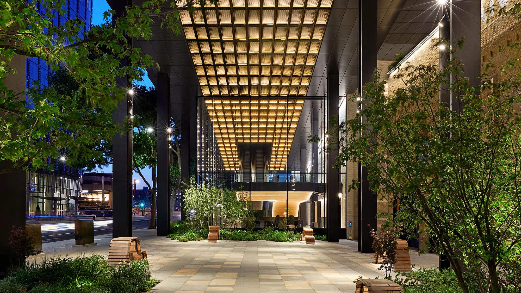 Illuminated coffered ceiling canopy over a public plaza and walkway by PLP Architecture at Arbor.