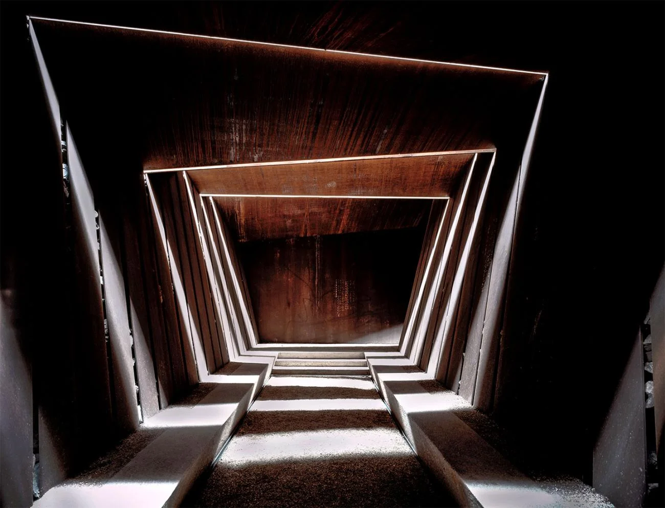 Subterranean corten steel corridor with slotted overhead light at Bell-Lloc Winery by RCR Arquitectes.